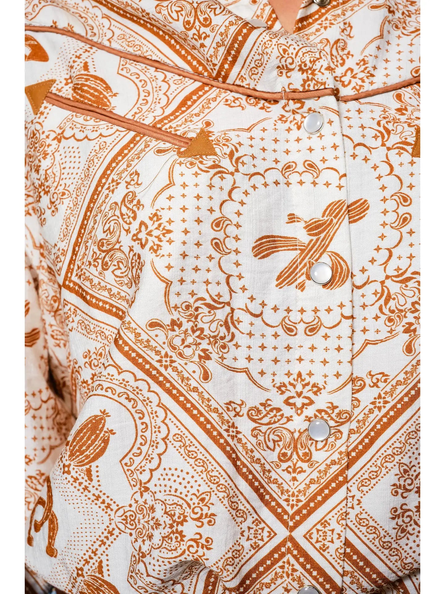 Woman wearing a western patterned blouse western color details snap shirt and jeans