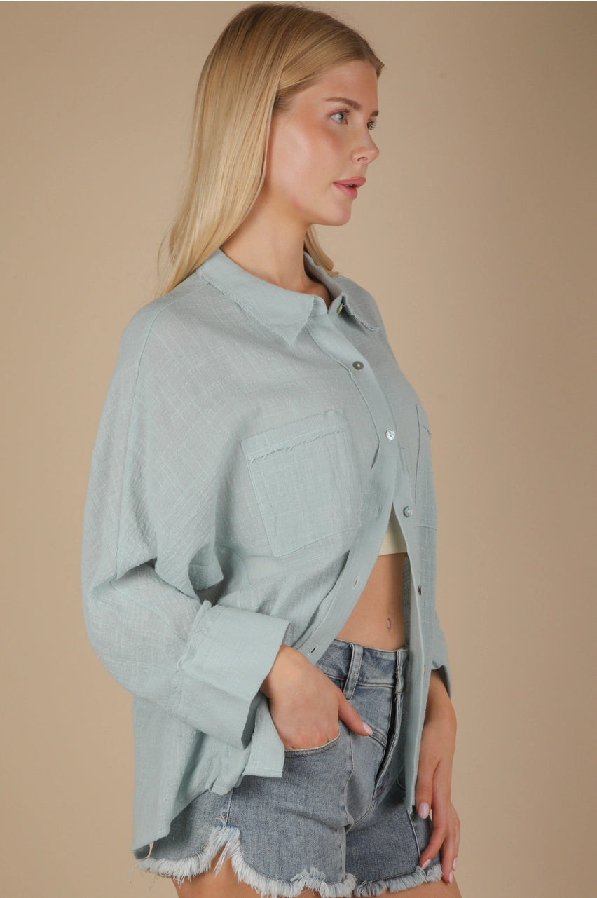 Side angle showing relaxed fit and side slit on sky blue gauze top