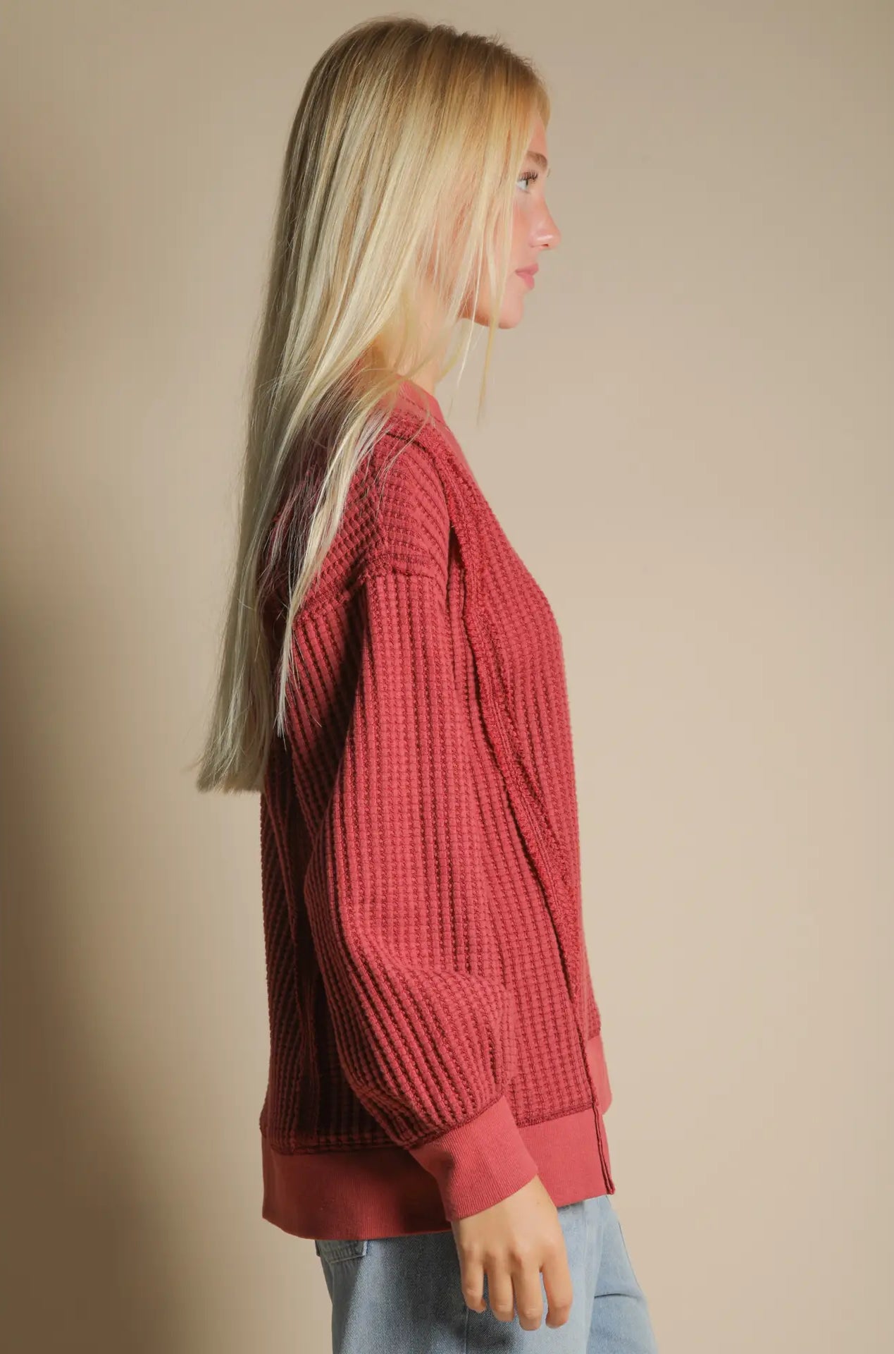 Side angle showing front slit and relaxed drape of waffle knit pullover