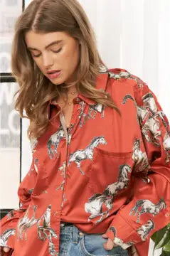 Woman wearing a rust shirt with horse print