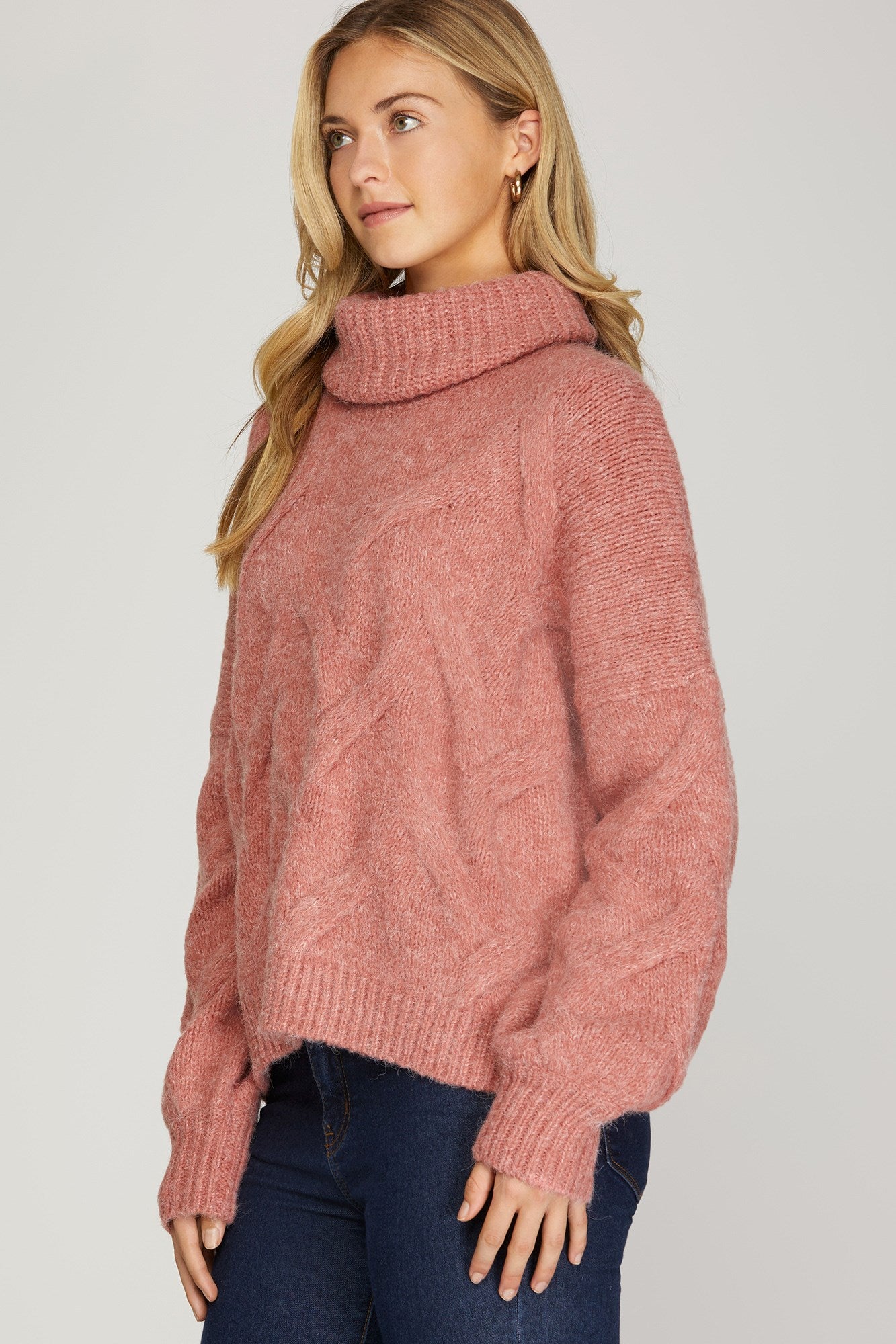 Front view of rosy-rust cable knit turtleneck sweater with ribbed cuffs and hem.