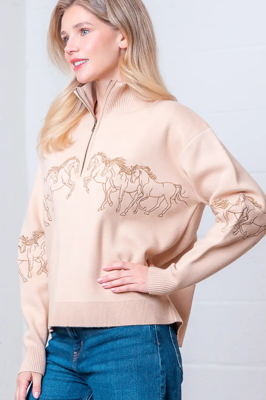 Taupe high-neck quarter-zip sweater with horse embroidery on model, front view.