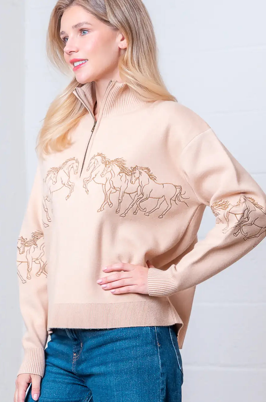 Taupe high-neck quarter-zip sweater with horse embroidery on model, front view.