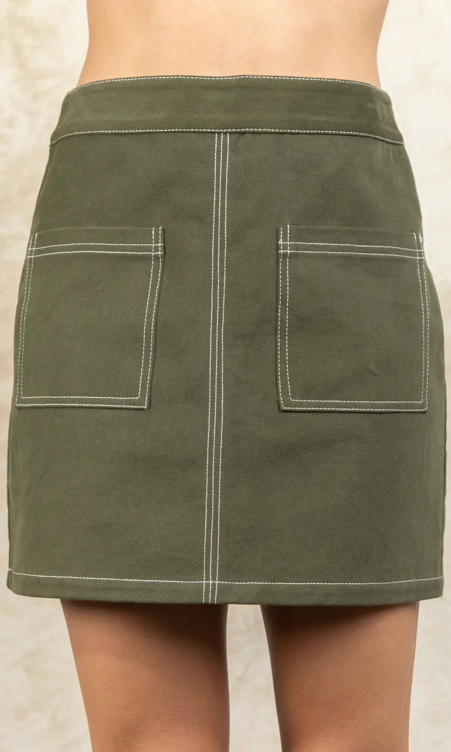 Green skirt with two front pockets on a neutral background