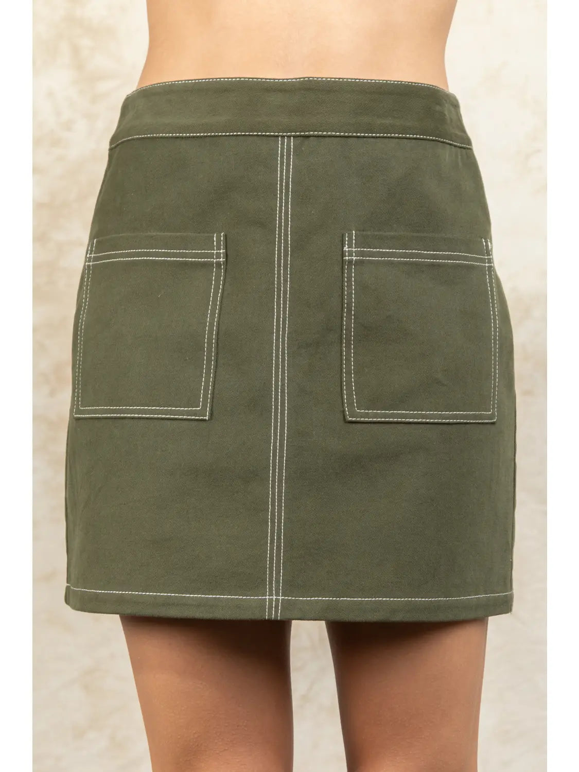 Green skirt with two front pockets on a neutral background
