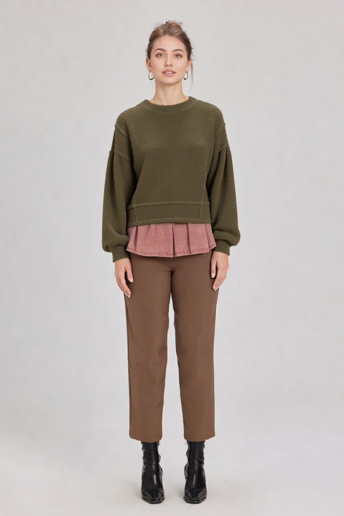 Woman in a olive round-neck textured knit oversized top with drop shoulders and long sleeves, relaxed fit.