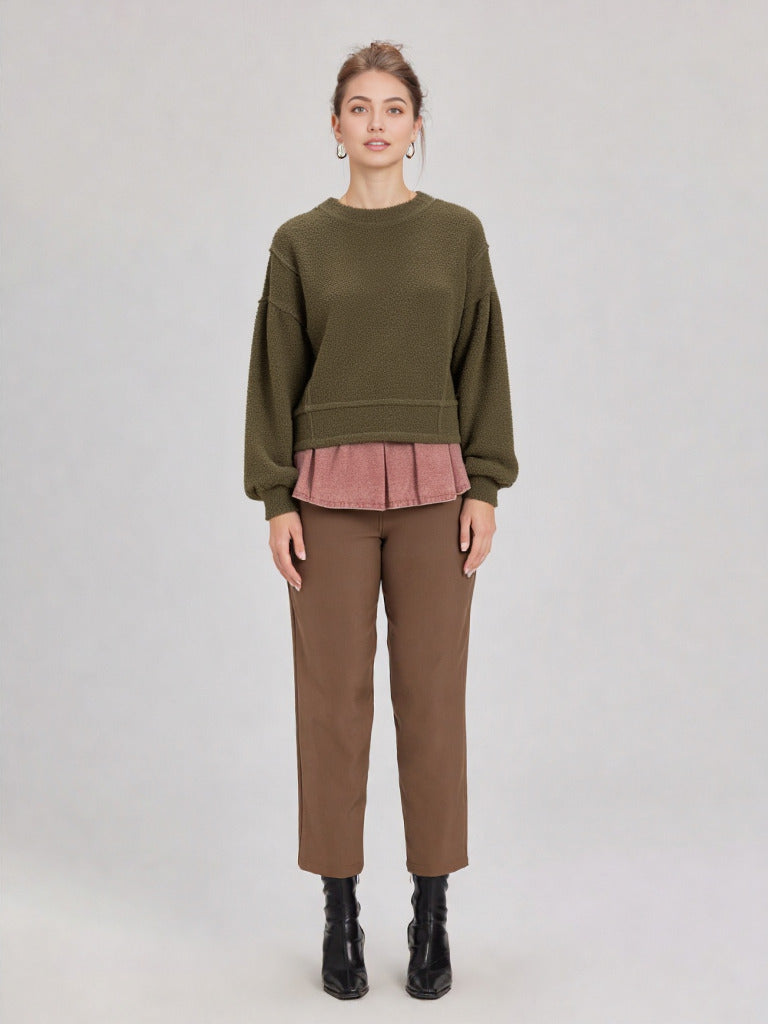 Woman in a olive round-neck textured knit oversized top with drop shoulders and long sleeves, relaxed fit.