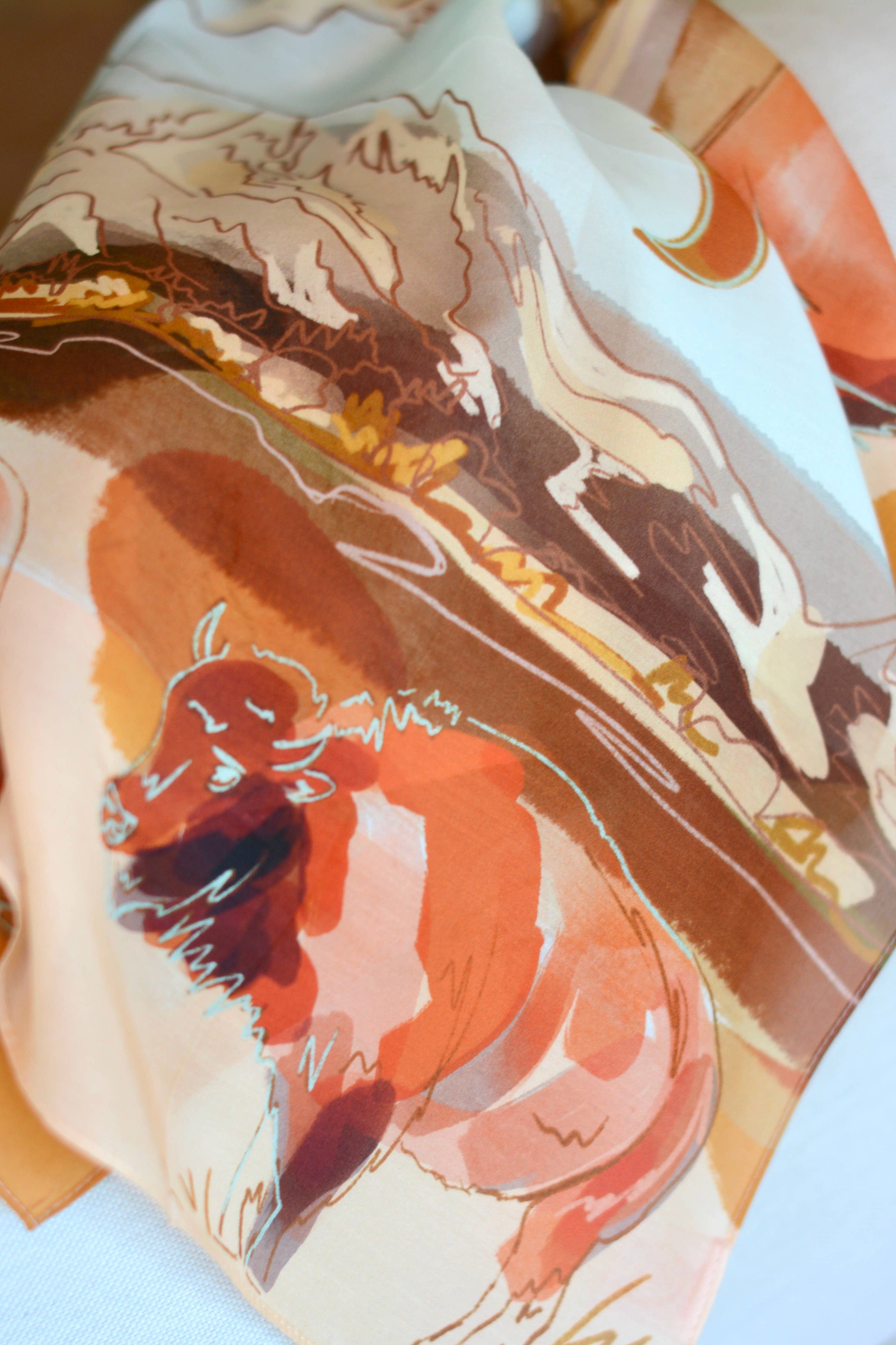 Close-up of a fabric with abstract art design featuring animals on a white background