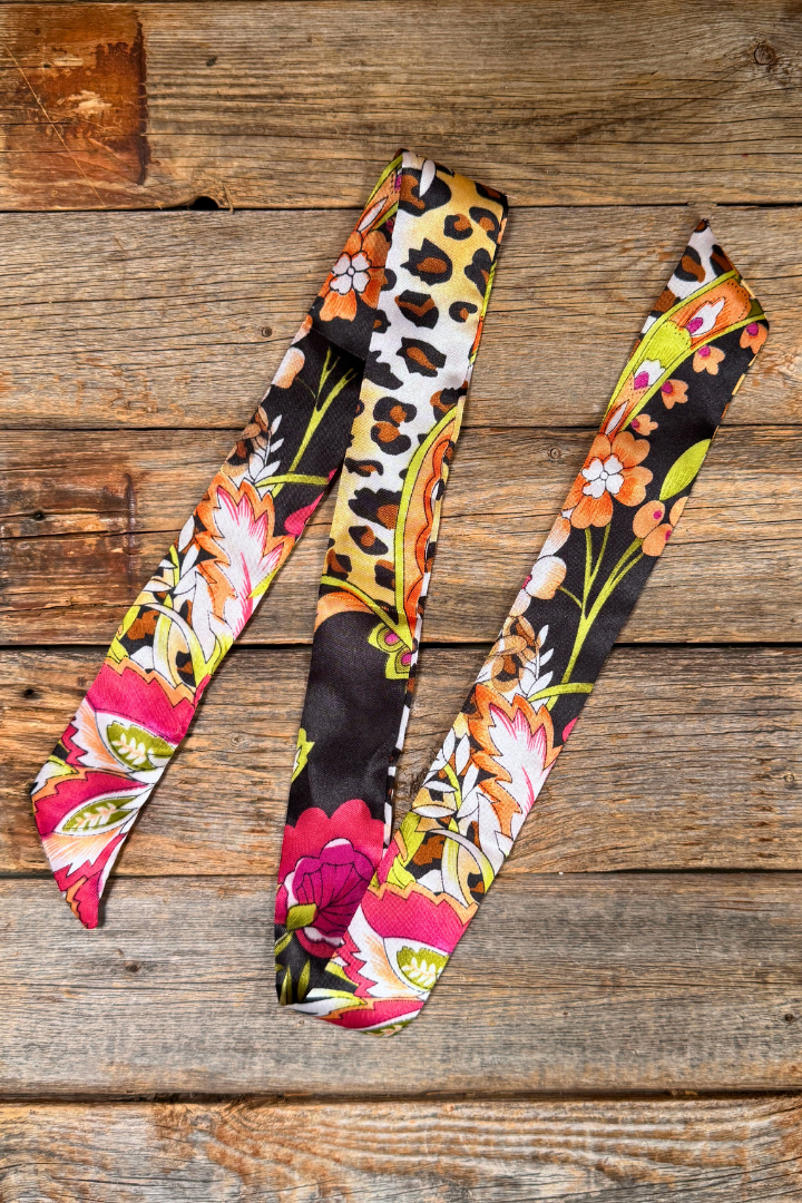Colorful floral and leopard print fabric strips on a wooden surface