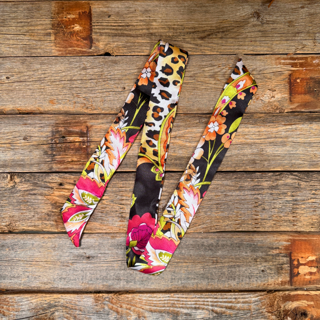 Colorful floral and leopard print fabric strips on a wooden surface