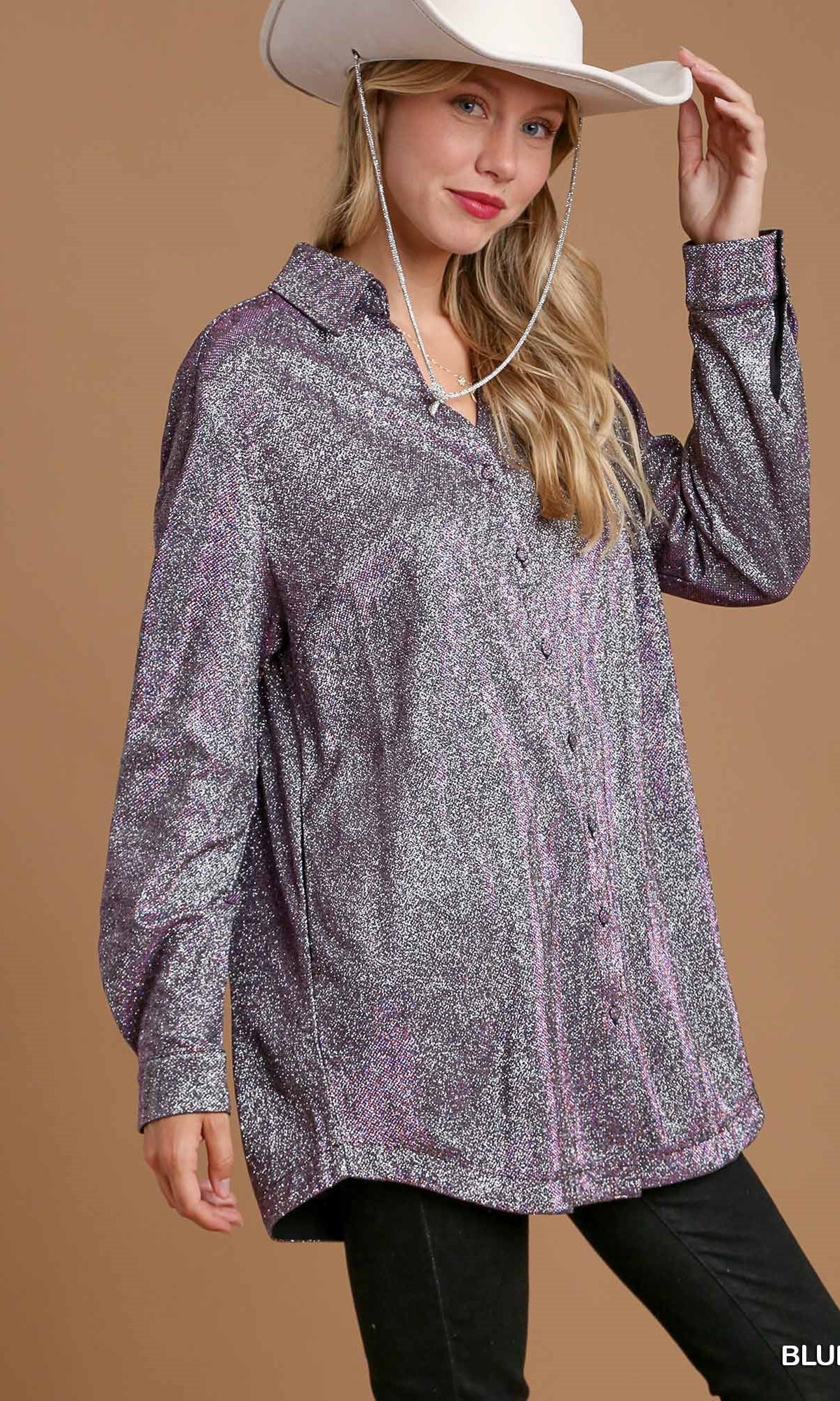 Woman wearing a patterned shirt and cowboy hat against a brown background