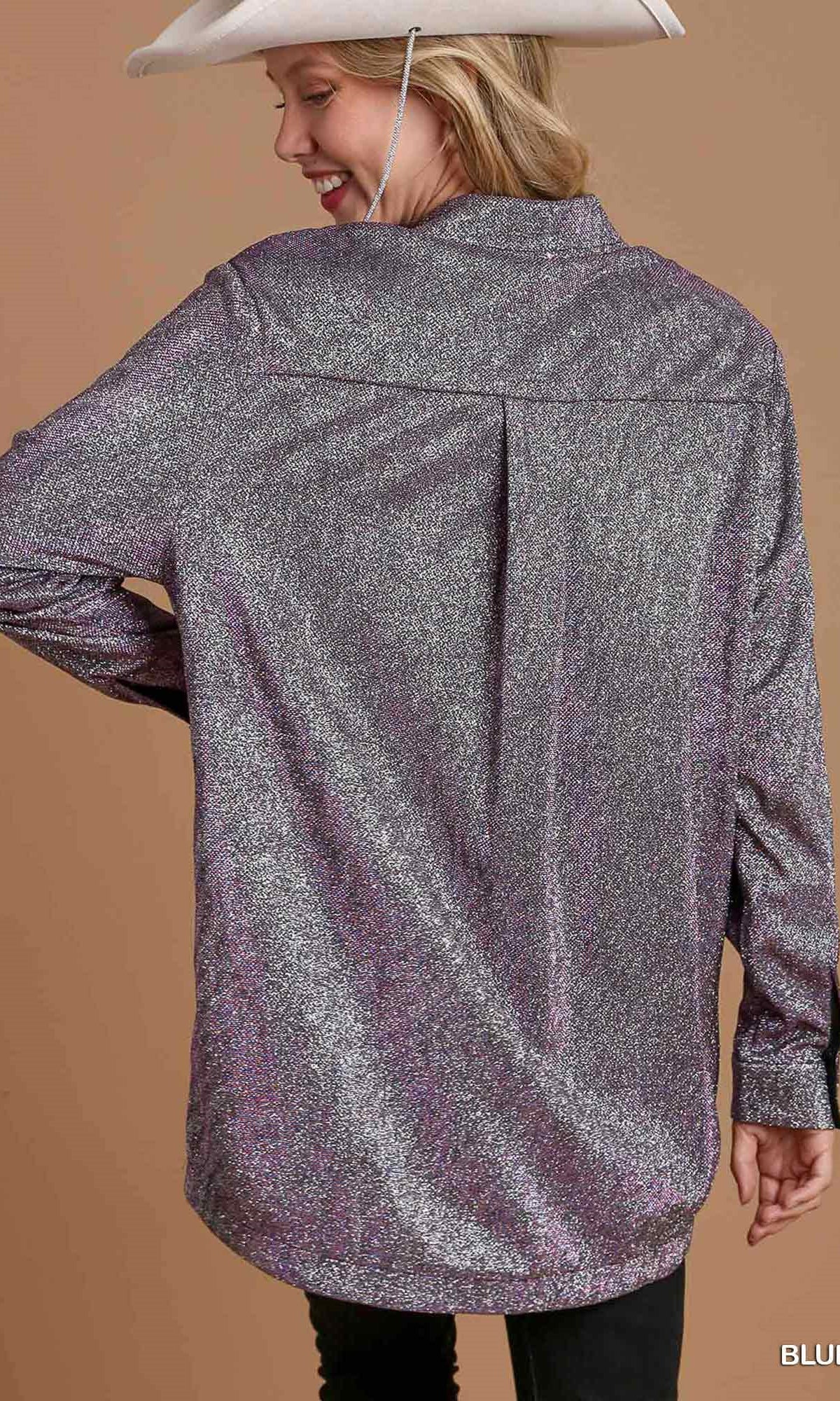 Person wearing a sparkly silver jacket on a brown background