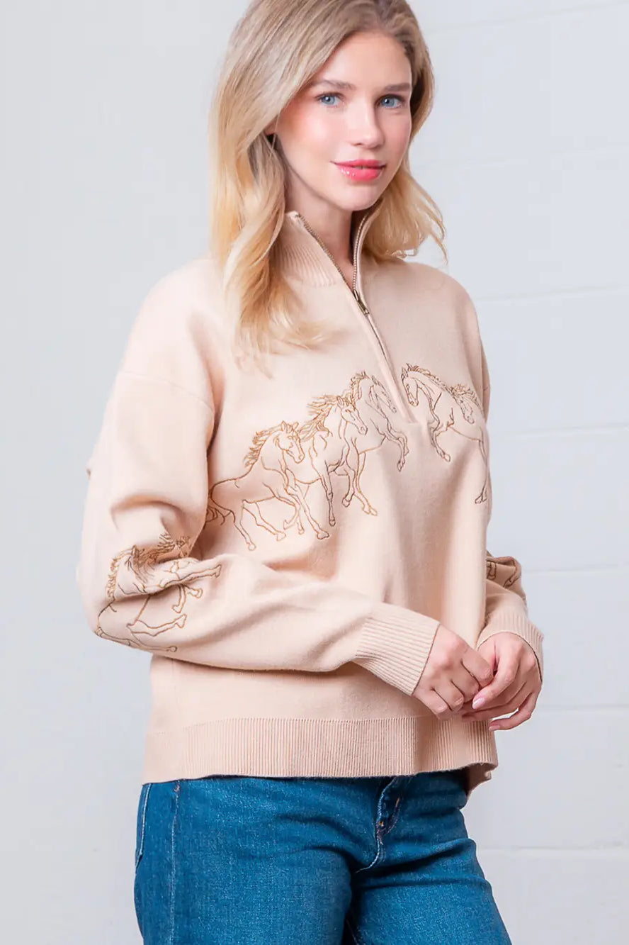 Taupe high-neck quarter-zip sweater with horse embroidery on model, front view.