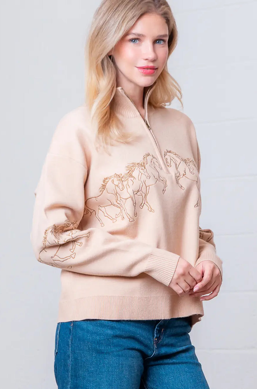 Taupe high-neck quarter-zip sweater with horse embroidery on model, front view.