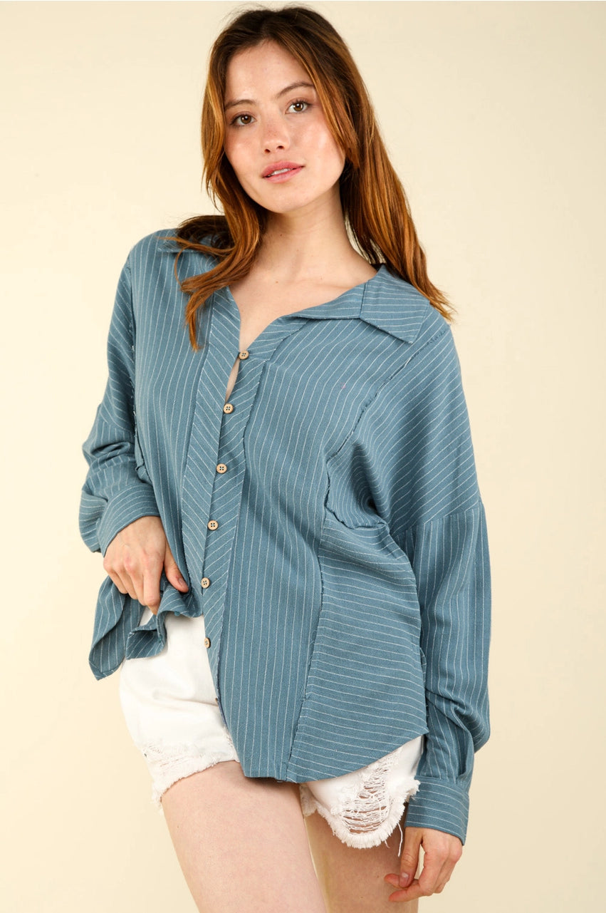 Model in dusty-blue striped linen-blend shirt, front angle; button front, chest pocket, drop shoulders, long sleeves.”