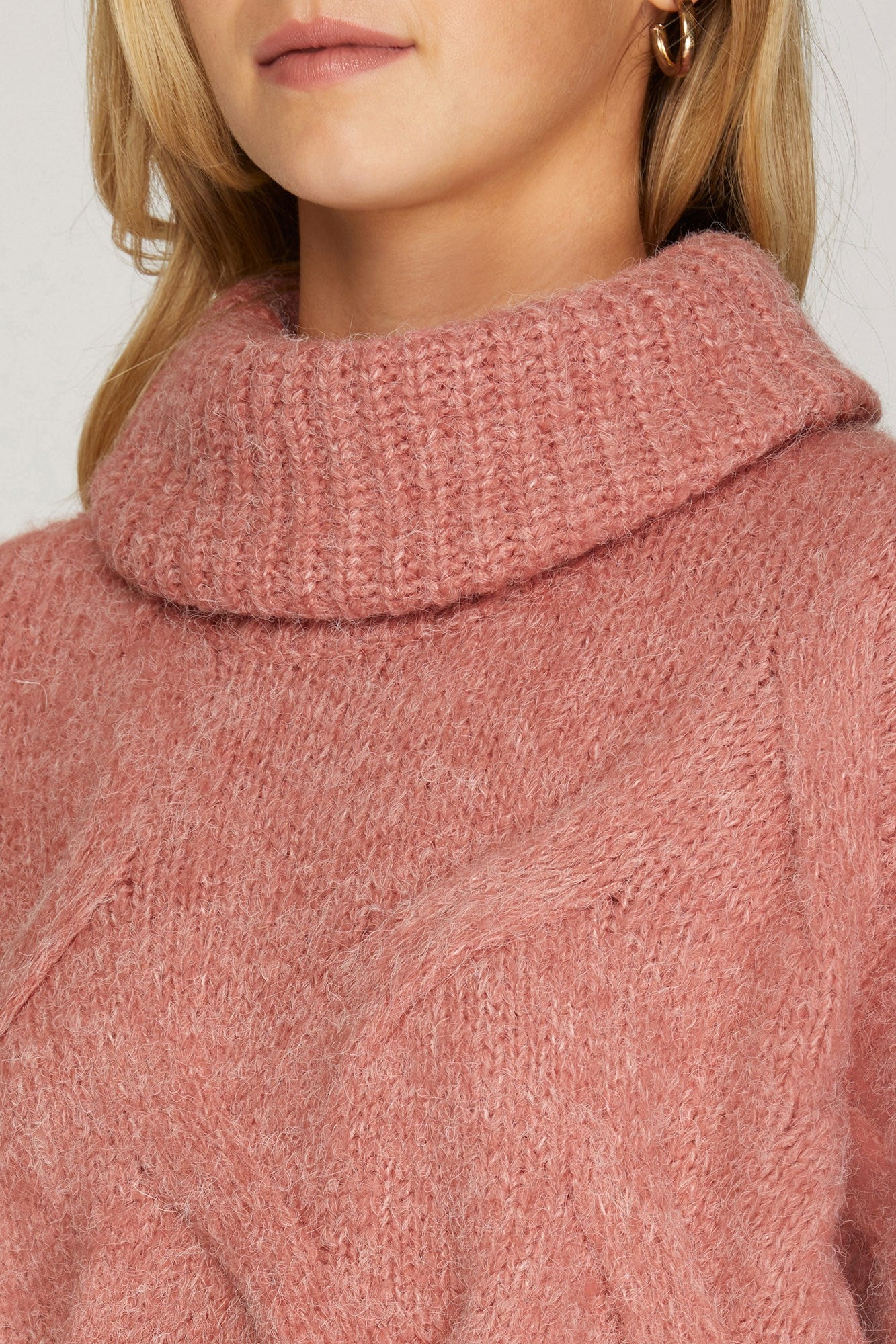 Close-up of cable texture and ribbed turtleneck in light rosy rust