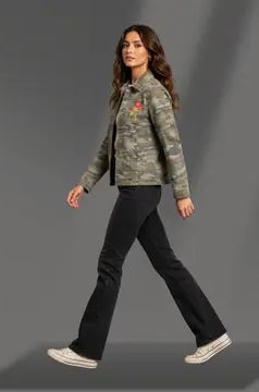 Woman wearing a camouflage jacket and black pants on a gray background