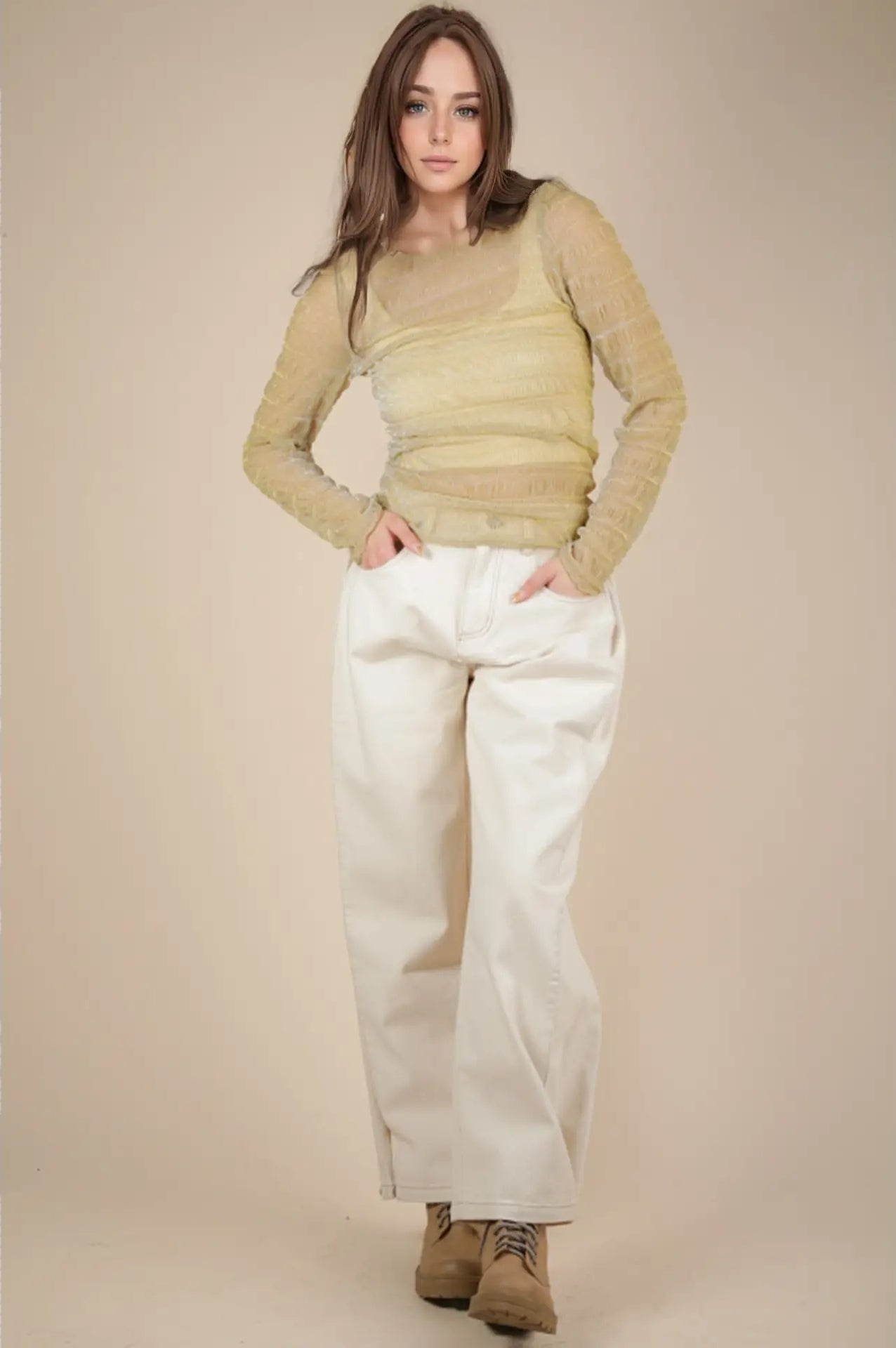 Front view: Model wearing champagne sheer lurex long-sleeve fitted top with crew/mock neck; subtle sparkle visible.