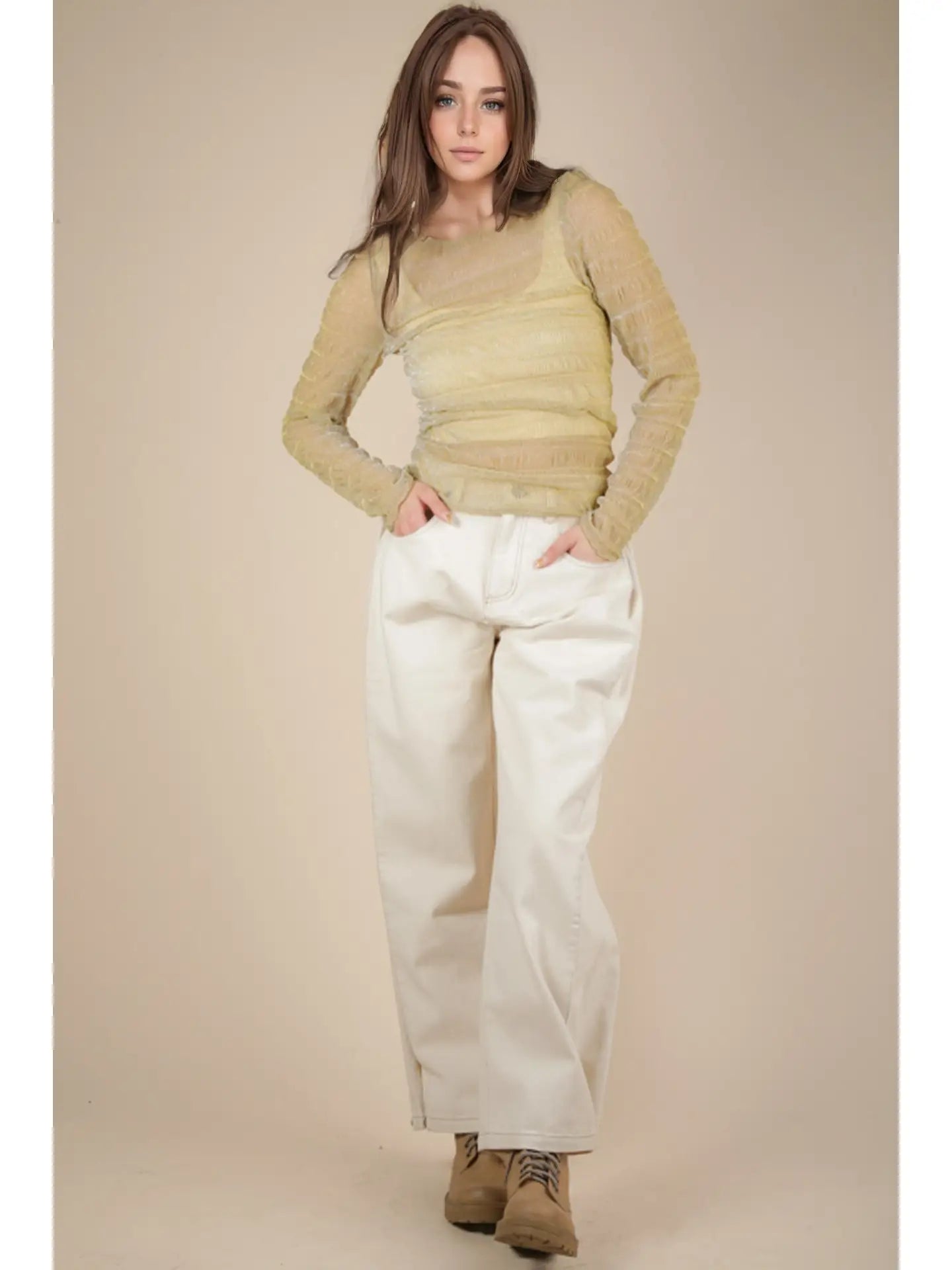 Front view: Model wearing champagne sheer lurex long-sleeve fitted top with crew/mock neck; subtle sparkle visible.