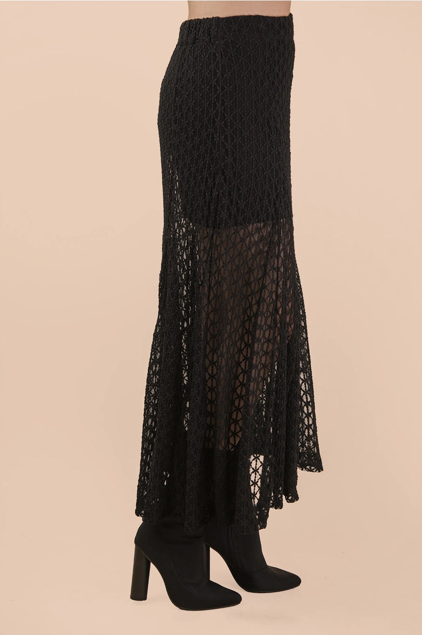 Black lace skirt with sheer panels on a beige background