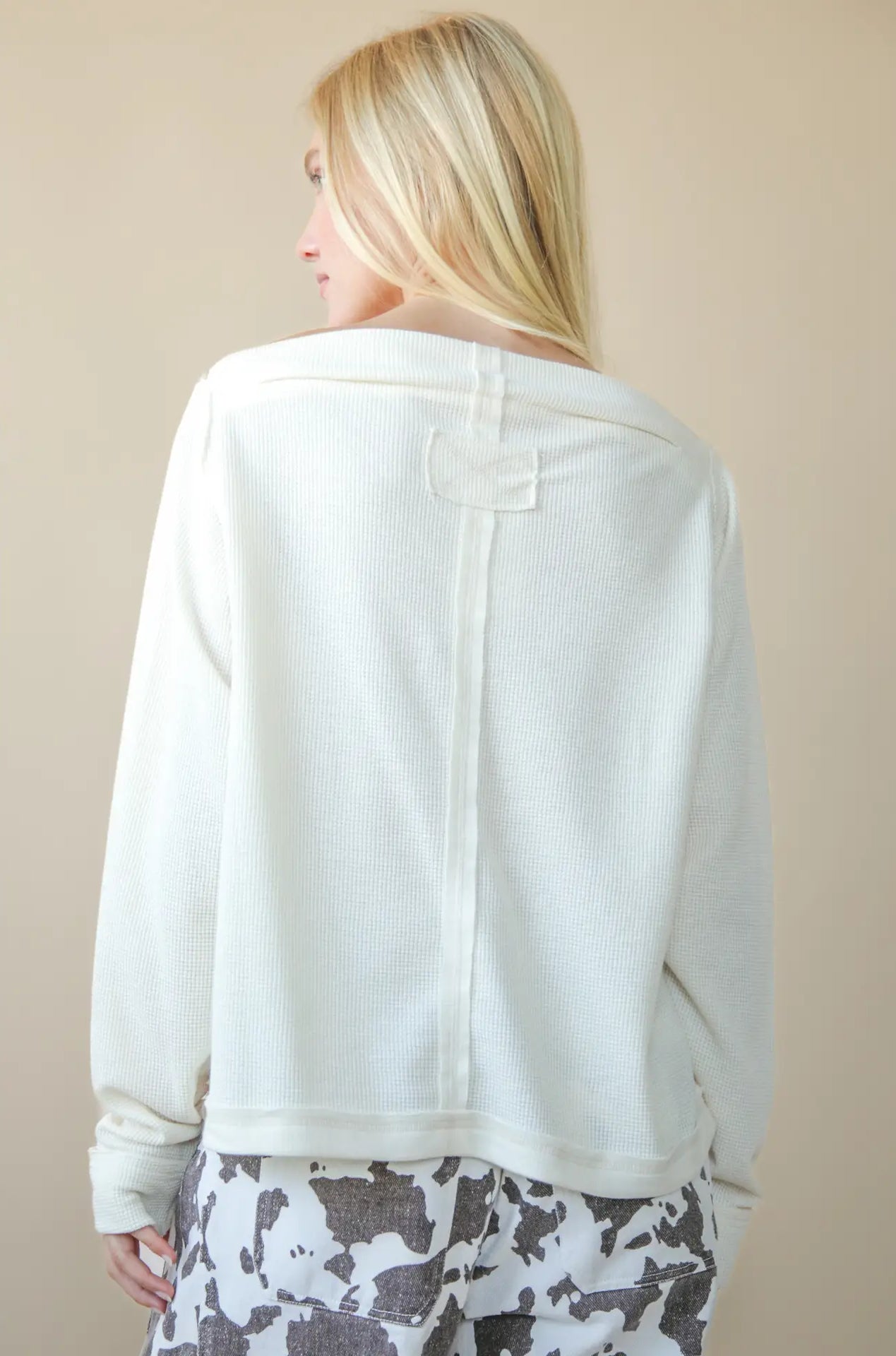 Back view of solid cotton knit top with long sleeves and clean hem