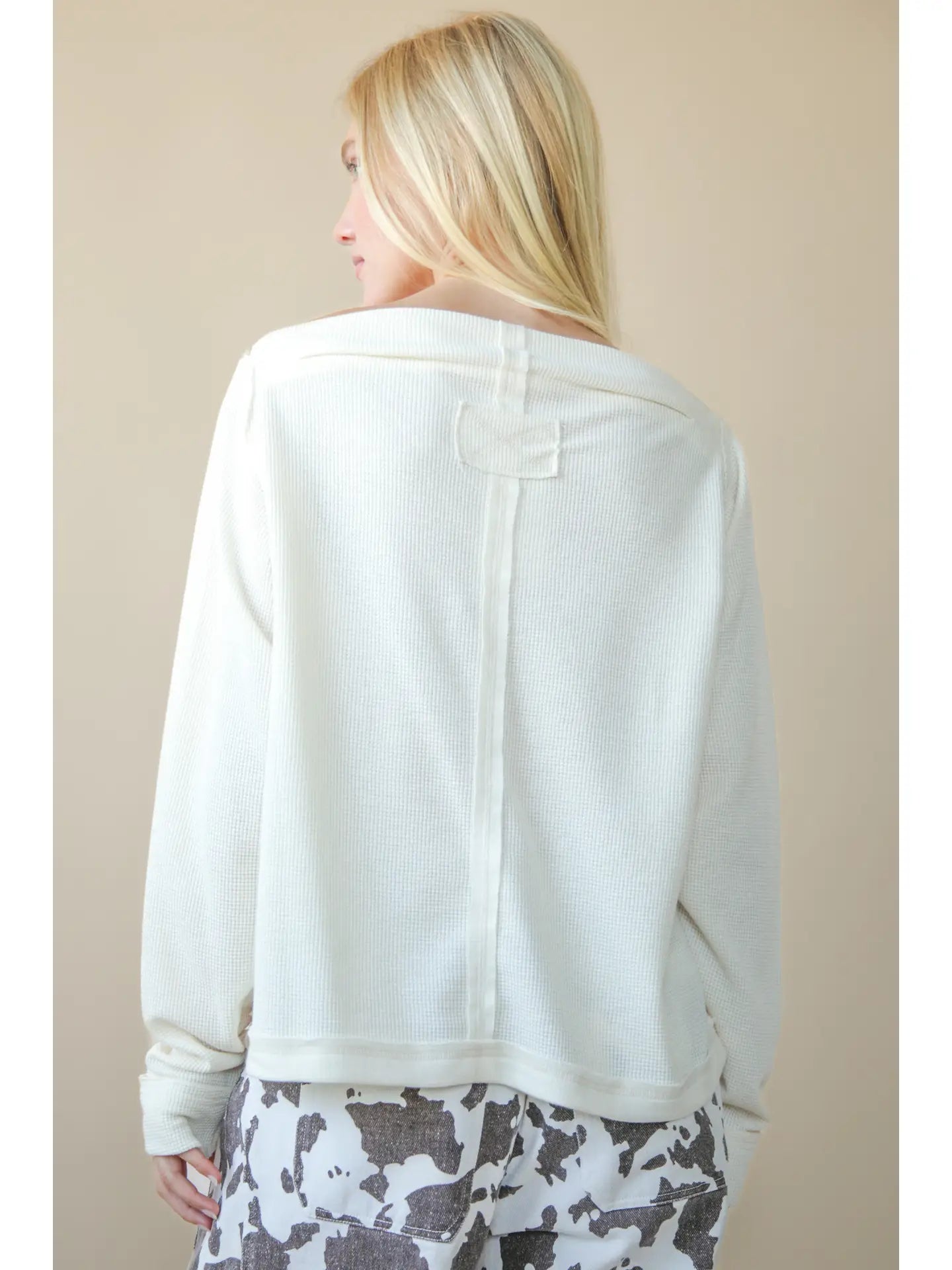 Back view of solid cotton knit top with long sleeves and clean hem