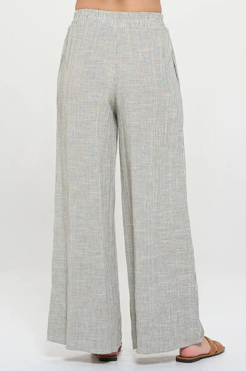 Light gray pin stripped pants worn with elastic waist by a person