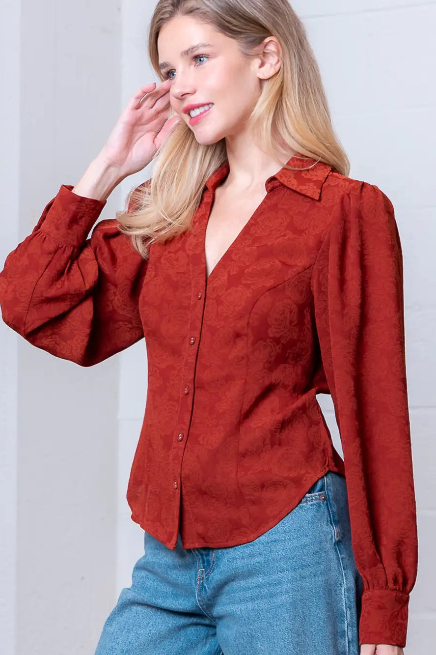 Front view of rust Western-inspired embossed blouse showing tailored waist and button front.