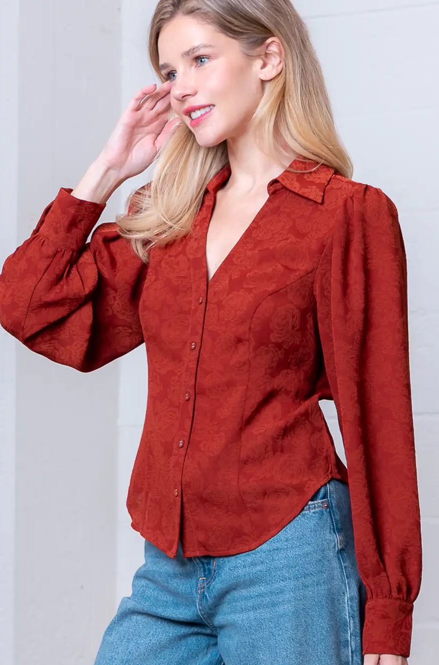 Front view of rust Western-inspired embossed blouse showing tailored waist and button front.