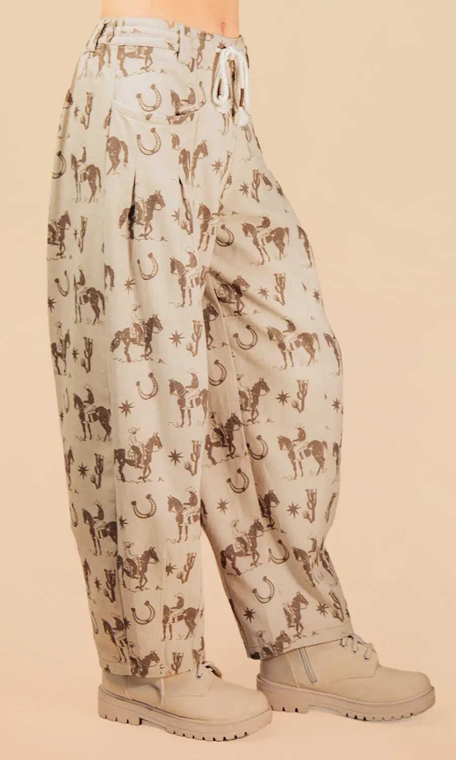 Light-colored pants with horse print worn by a person on a beige background