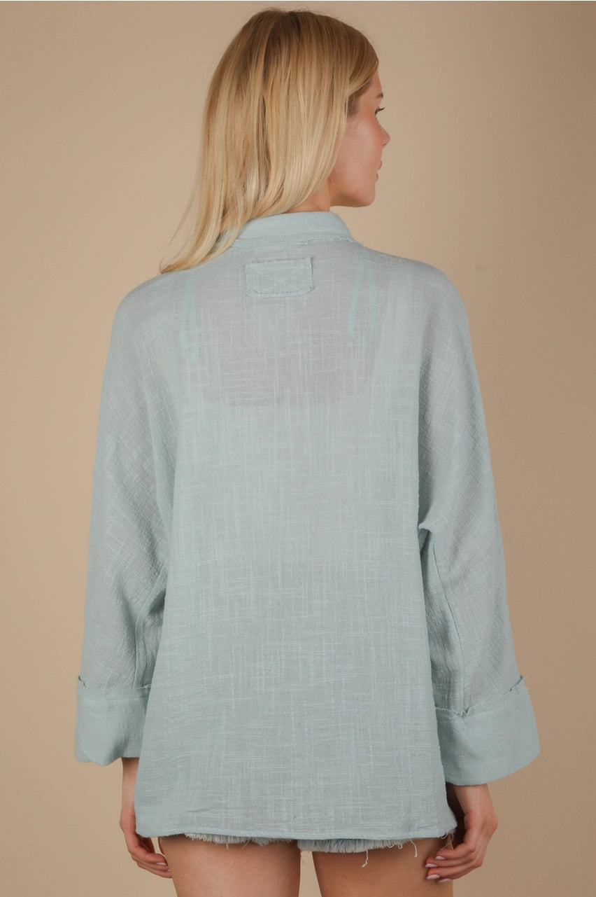Back view of oversized gauze button-down with dolman sleeves