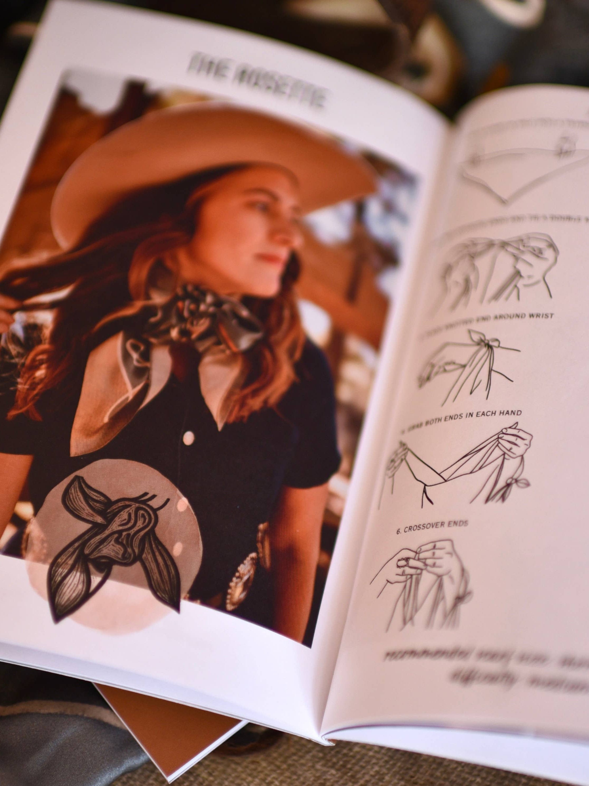 Open book with illustrations and a photo of a person wearing a hat and scarf, on a textured surface.