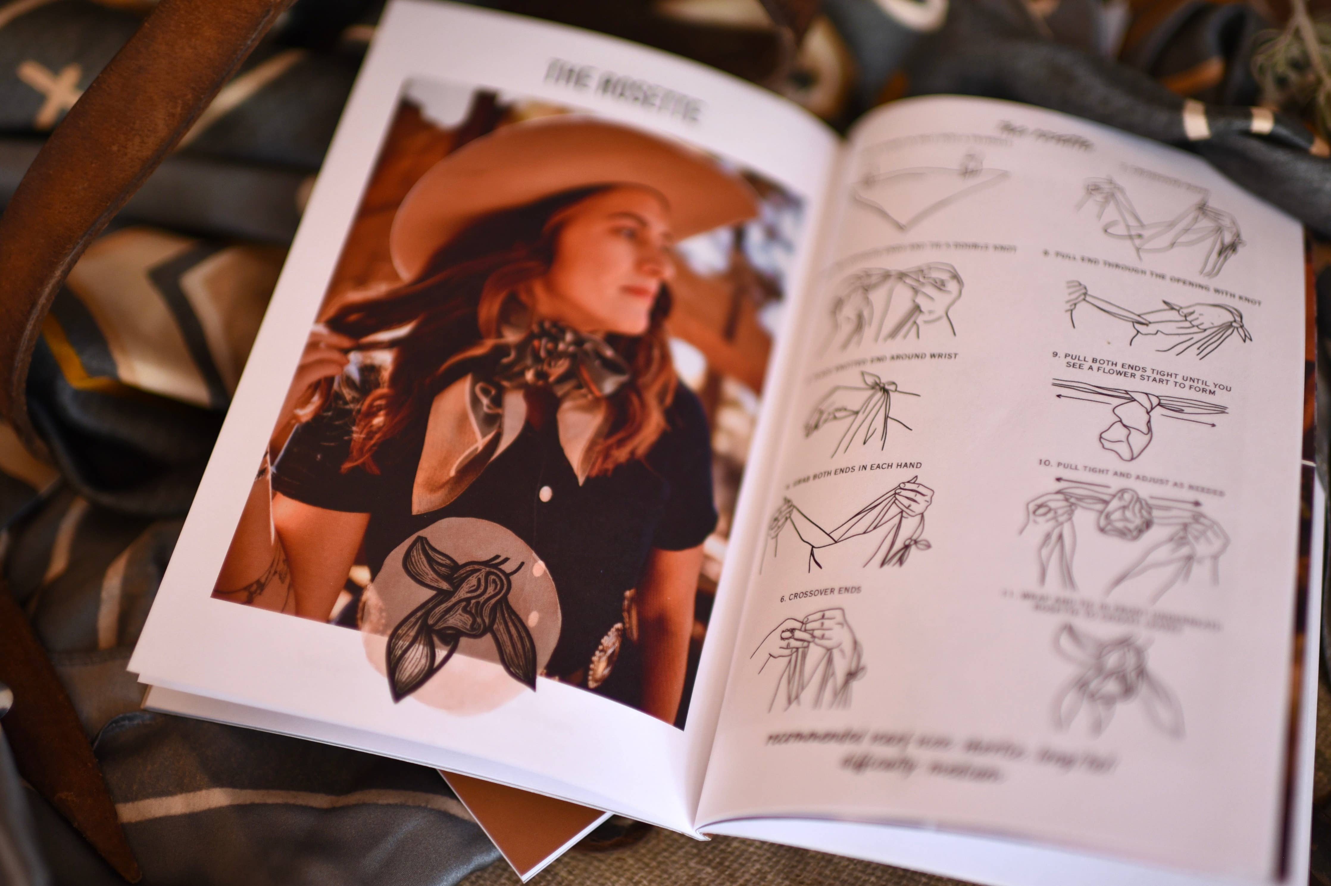 Open book with illustrations and a photo of a person wearing a hat and scarf, on a textured surface.