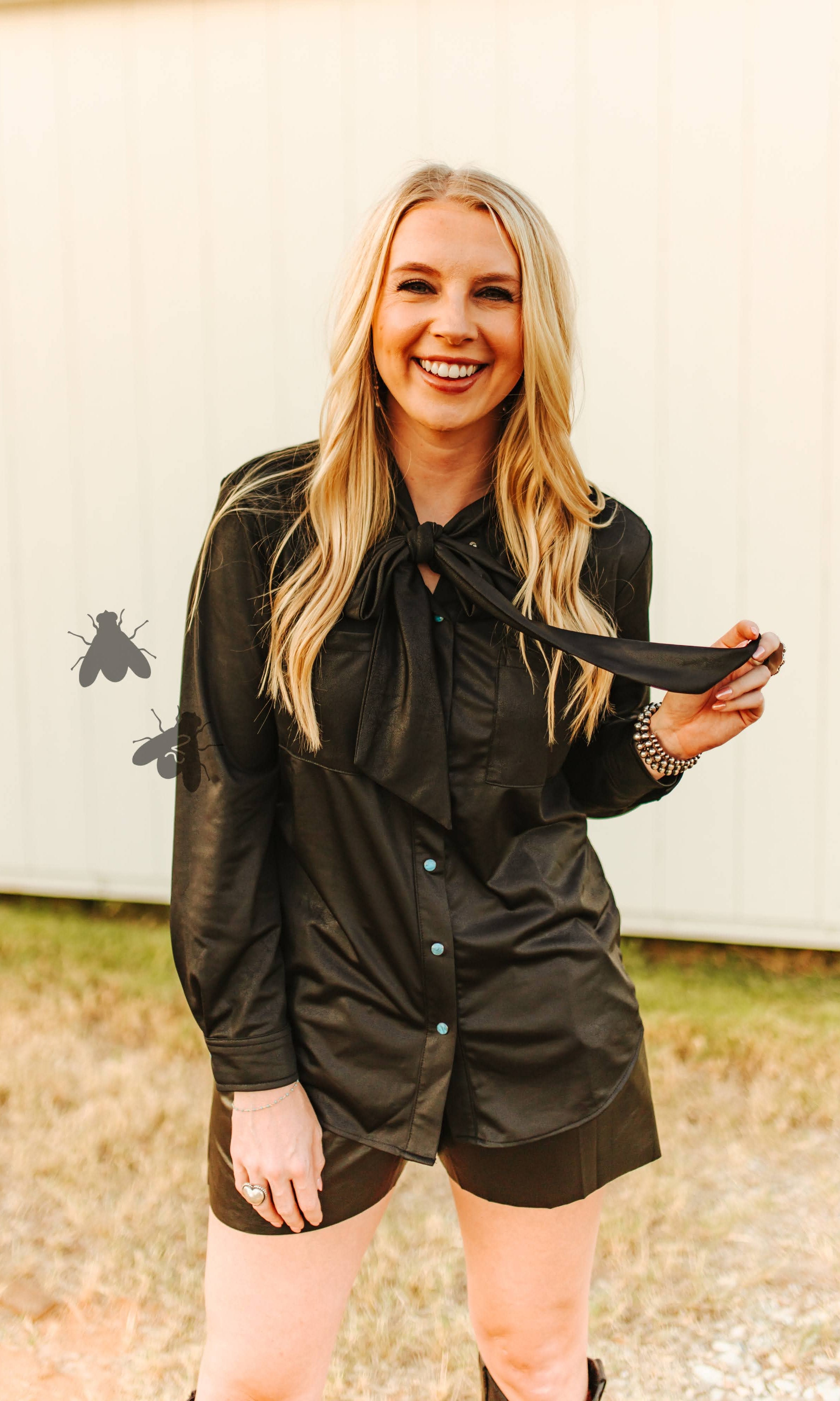 Woman in a black shirt and shorts outfit outdoors.
