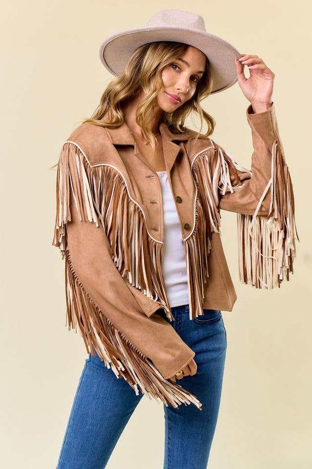 Woman wearing a brown fringe jacket and hat on a beige background