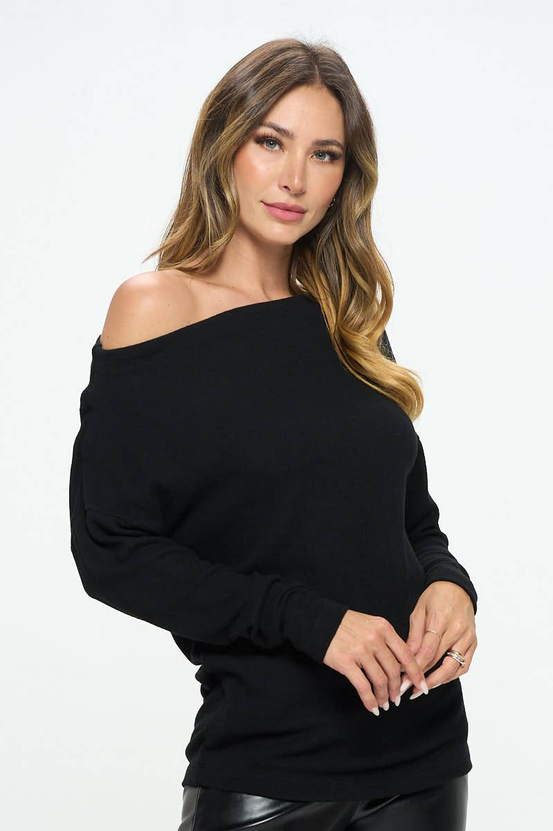 Woman wearing a black off-shoulder top against a white background