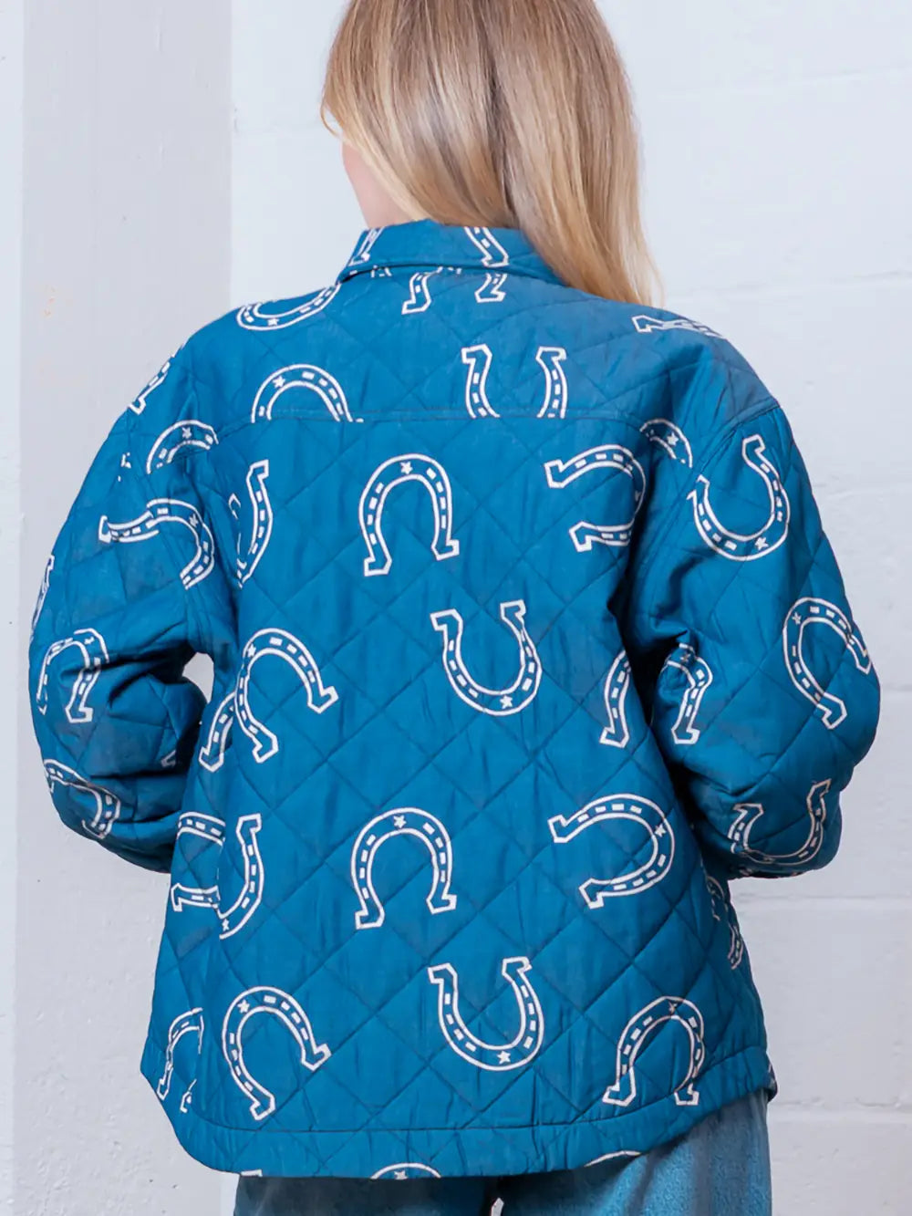 Back view highlighting overall horseshoe pattern on blue quilted coat.