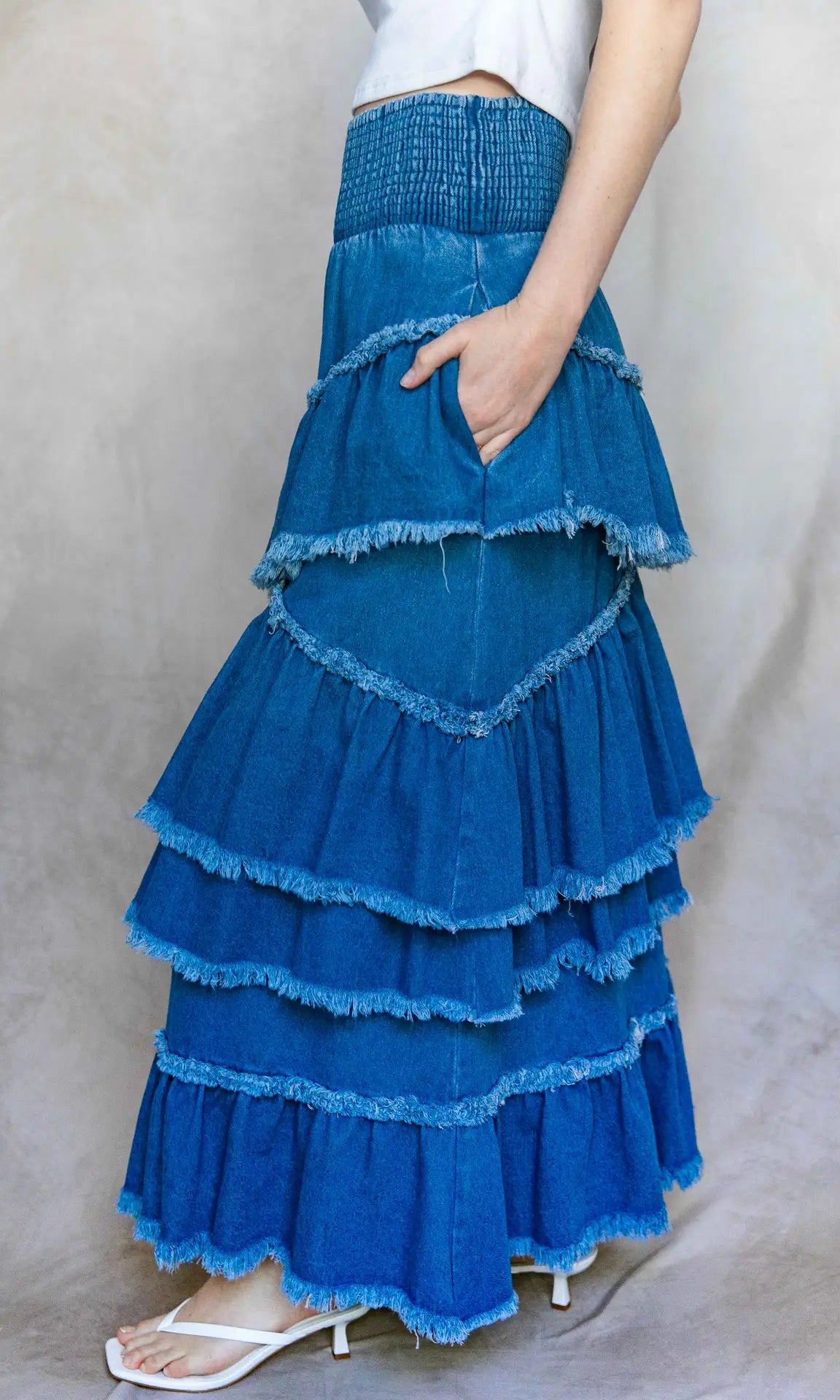 Blue tiered skirt worn by a person on a plain background