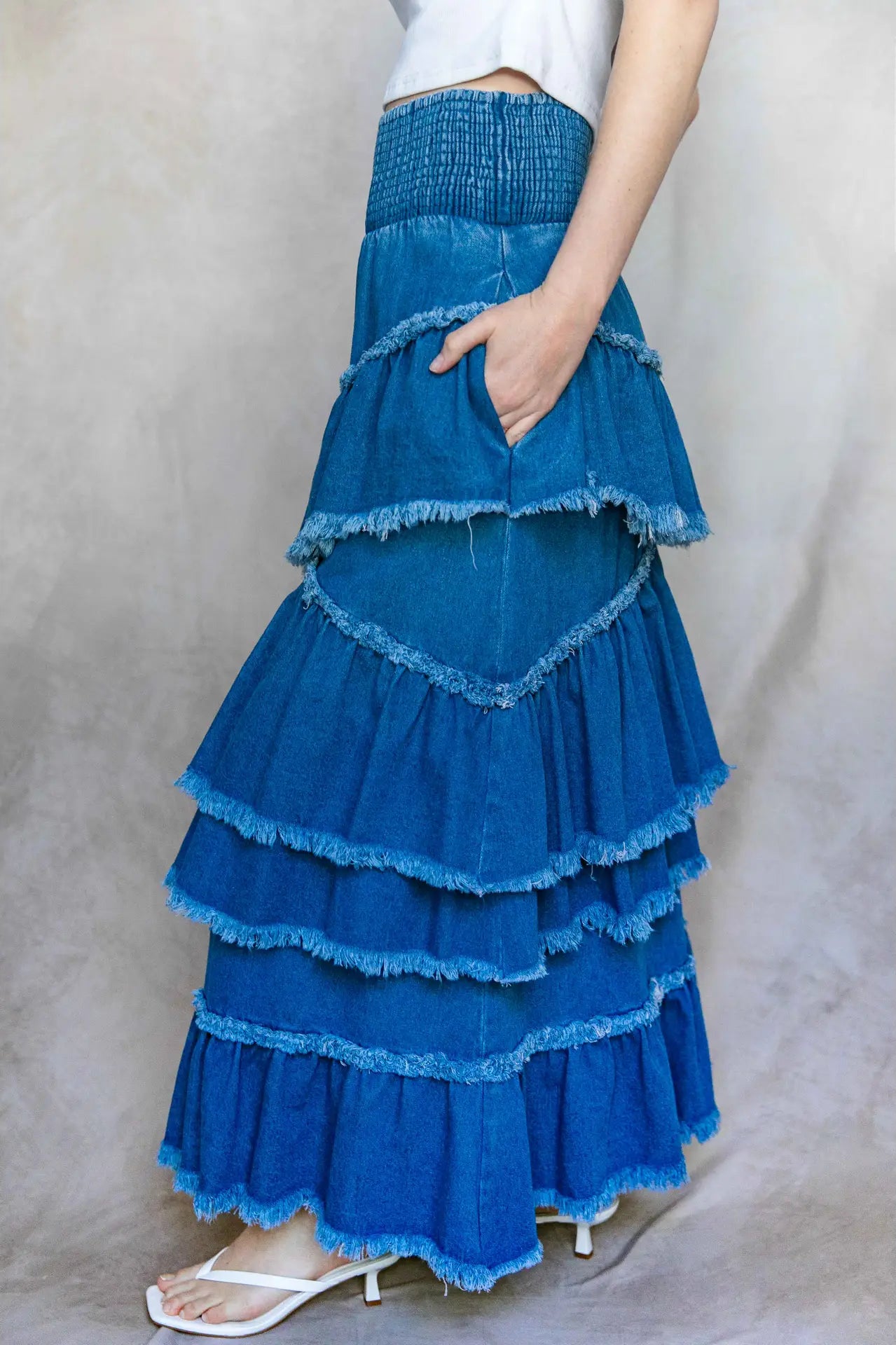 Blue tiered skirt worn by a person on a plain background