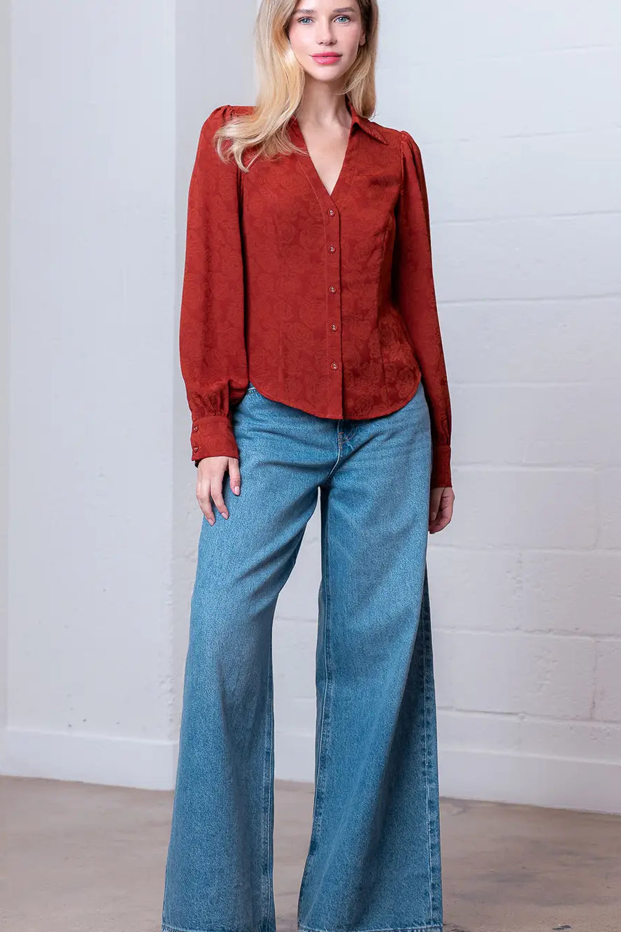 Front view of rust Western-inspired embossed blouse showing tailored waist and button front.
