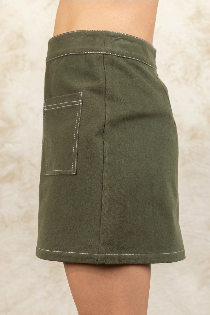 Green skirt worn by a person on a beige background