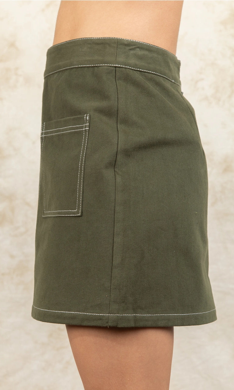 Green skirt worn by a person on a beige background