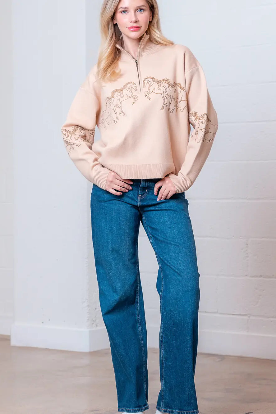 Taupe high-neck quarter-zip sweater with horse embroidery on model, front view.