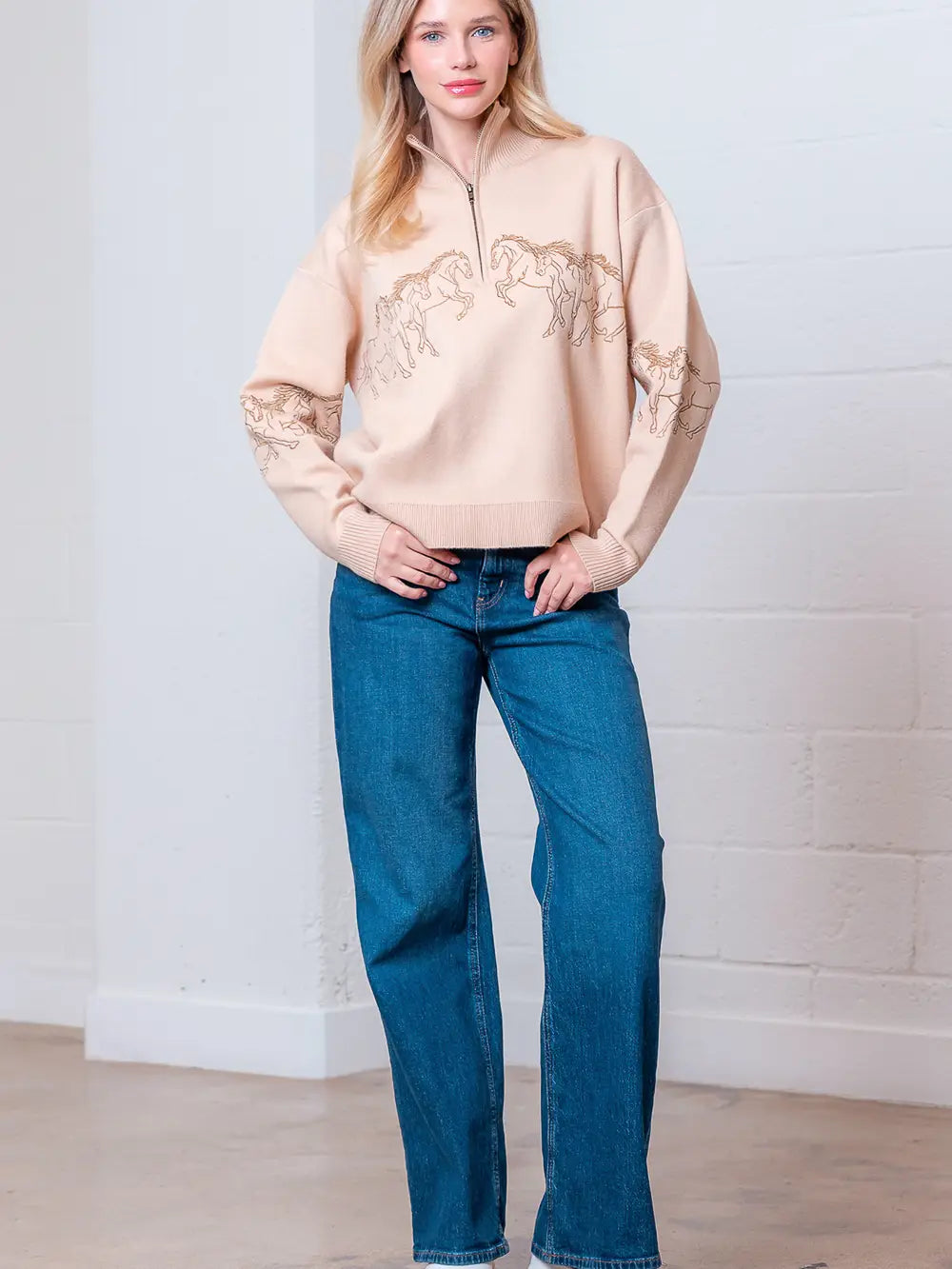 Taupe high-neck quarter-zip sweater with horse embroidery on model, front view.