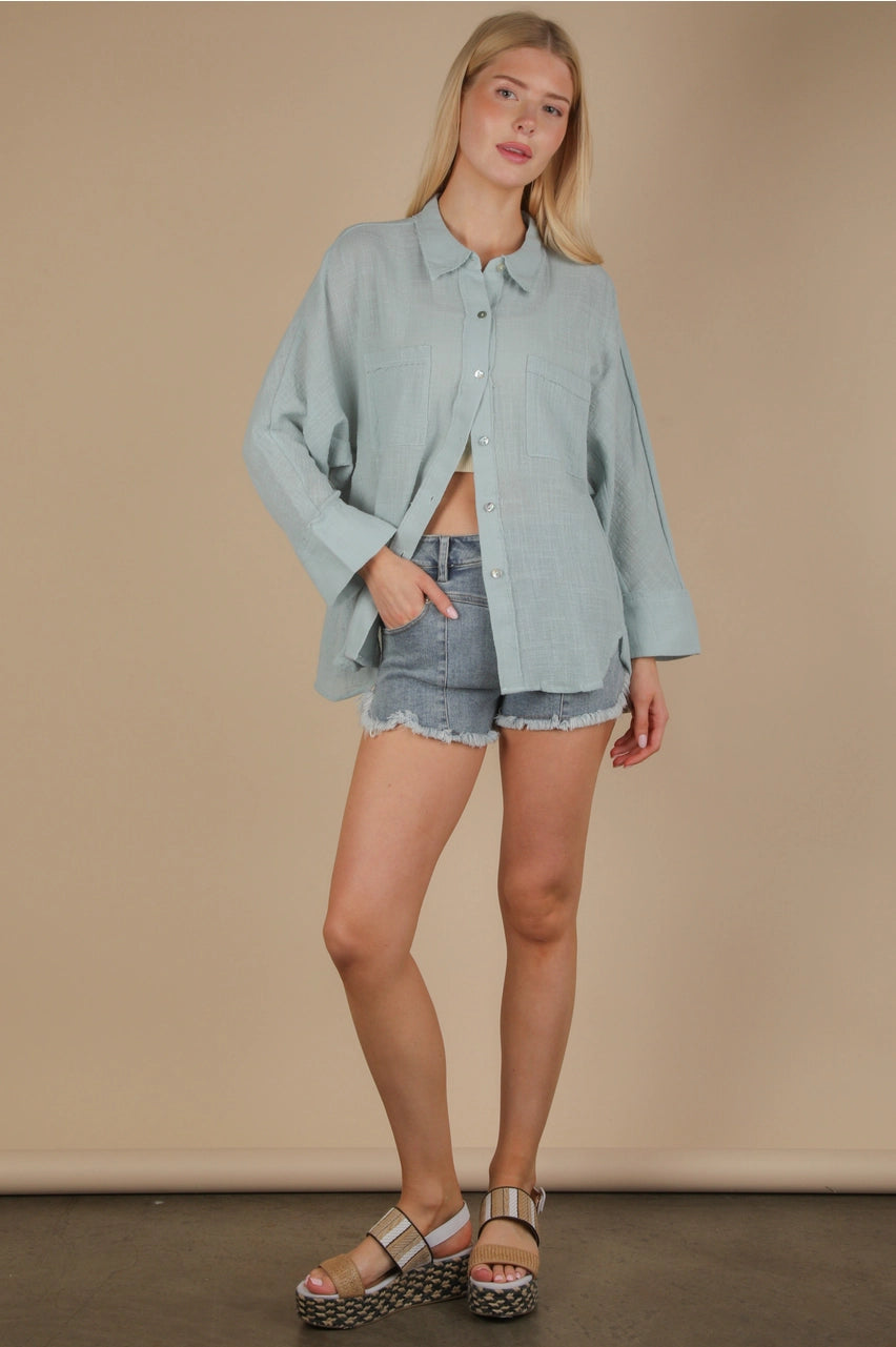 Front view of sky blue dolman-sleeve gauze button-down with patch pockets