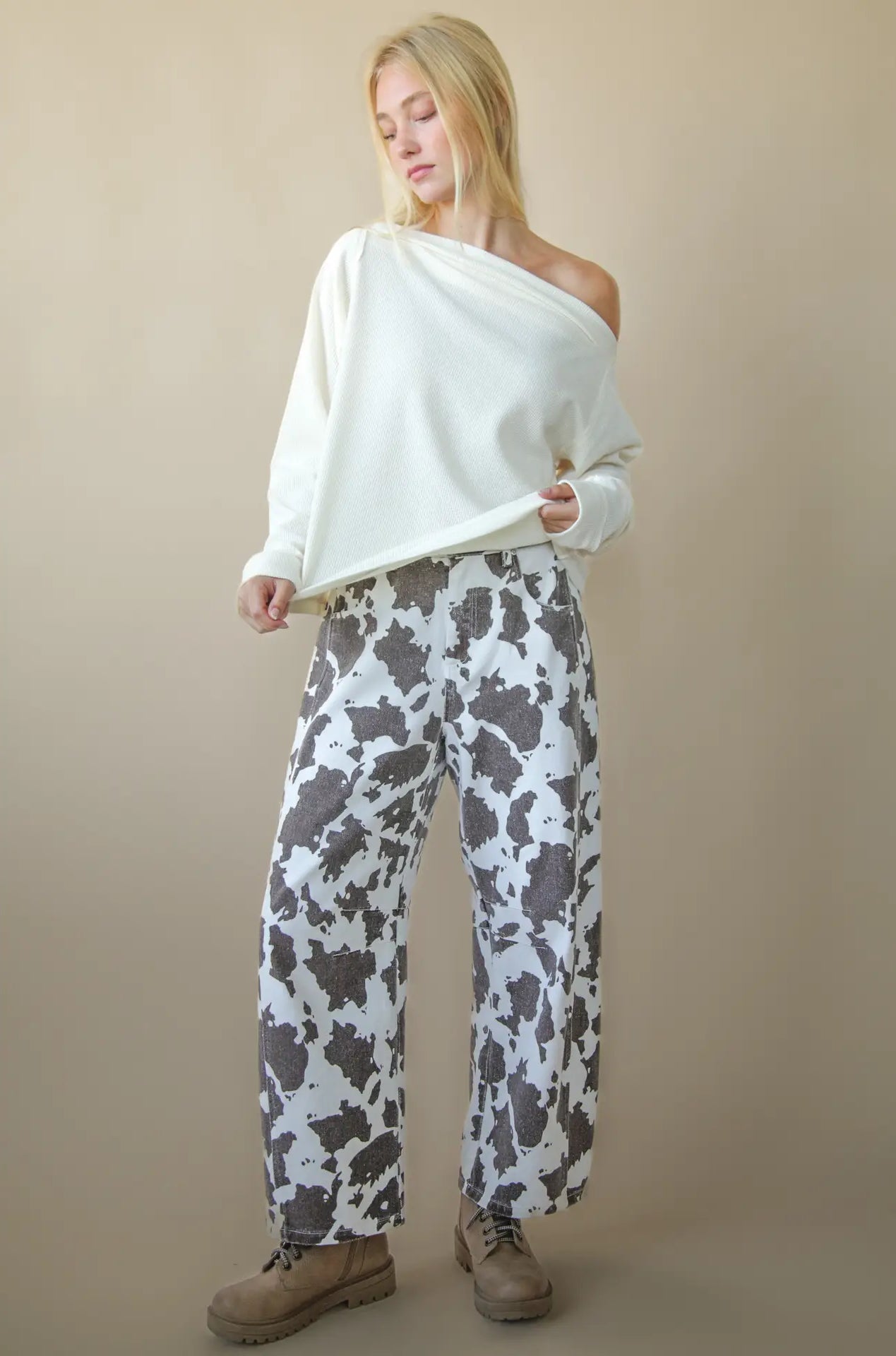 Front view of solid boat-neck cotton knit top worn slightly off-shoulder, long sleeves