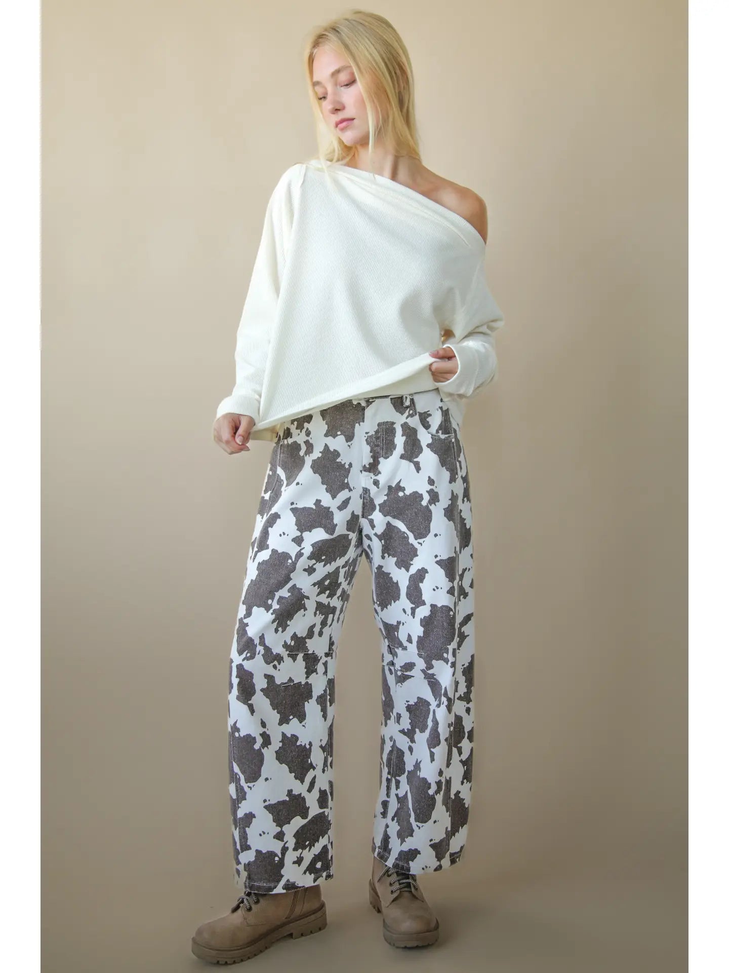 Front view of solid boat-neck cotton knit top worn slightly off-shoulder, long sleeves