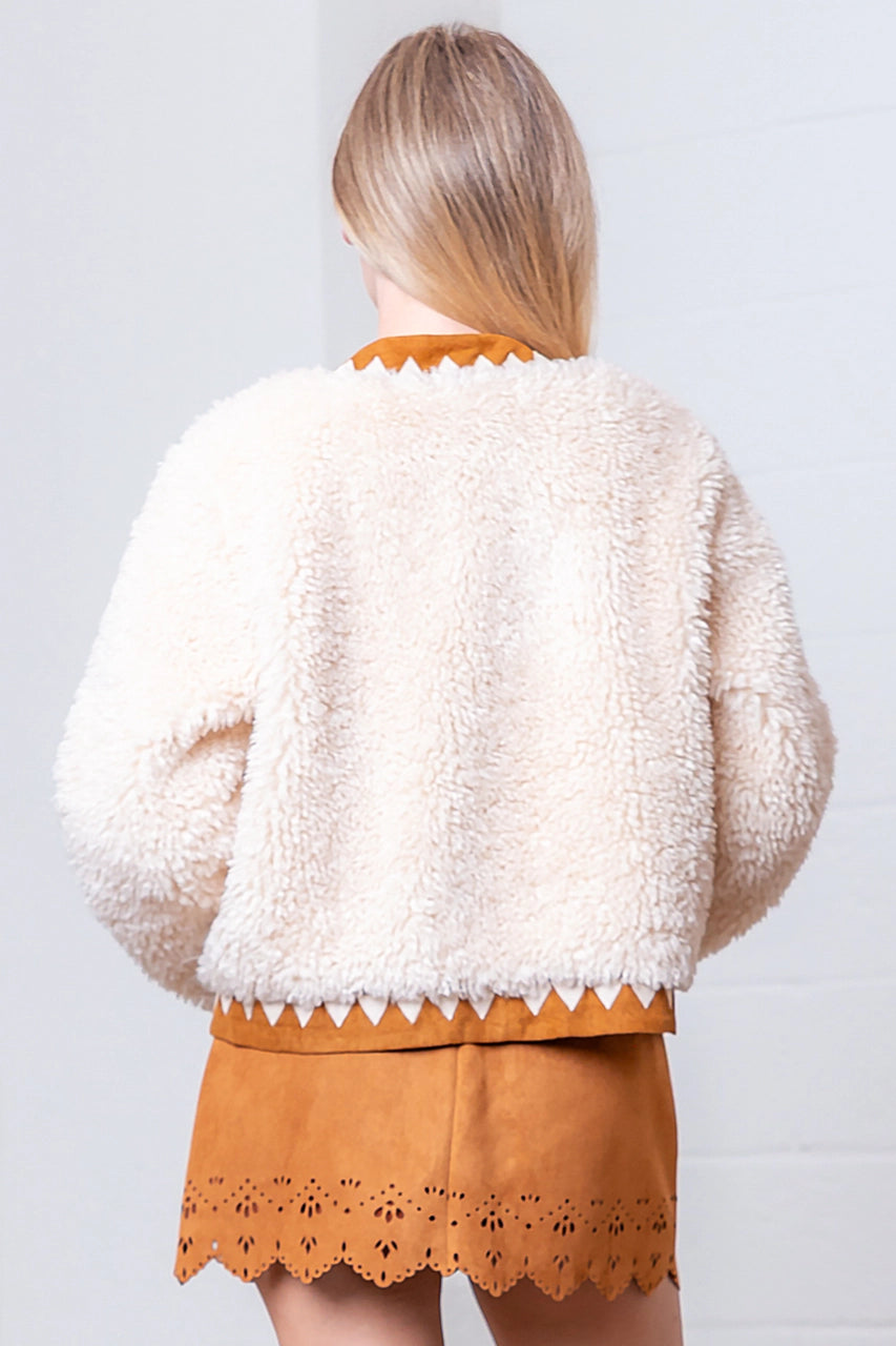 Back of cream faux-fur jacket showing suede-contrast hem, cuffs, and collar.