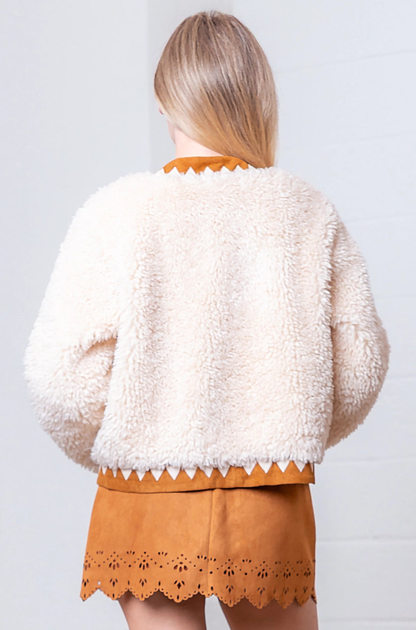 Back of cream faux-fur jacket showing suede-contrast hem, cuffs, and collar.