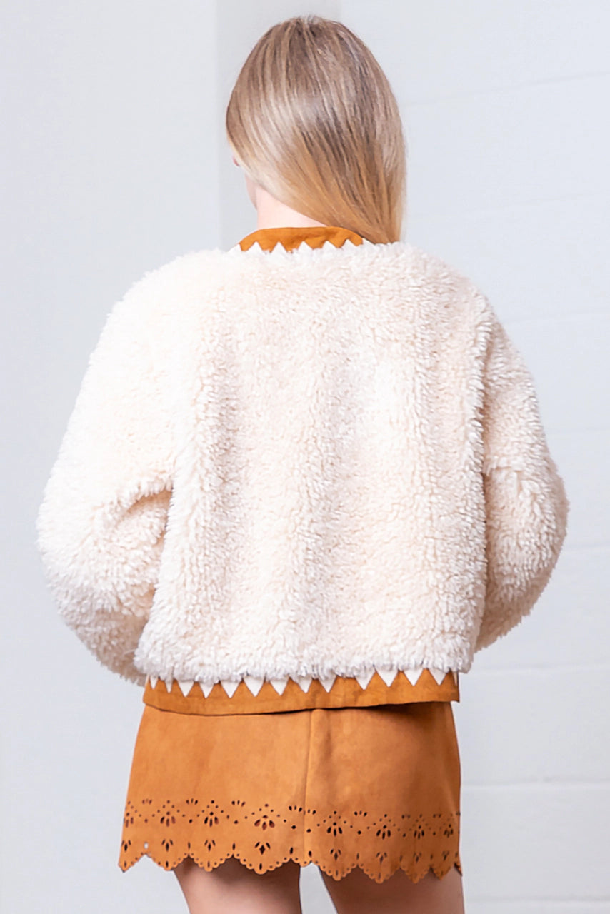 Back of cream faux-fur jacket showing suede-contrast hem, cuffs, and collar.